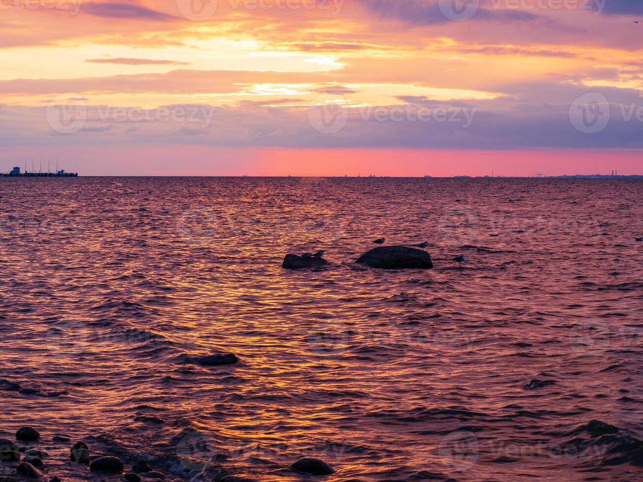 Scenic sunset on the sea. The sky is painted with bright colors. Cloudy summer evening photo