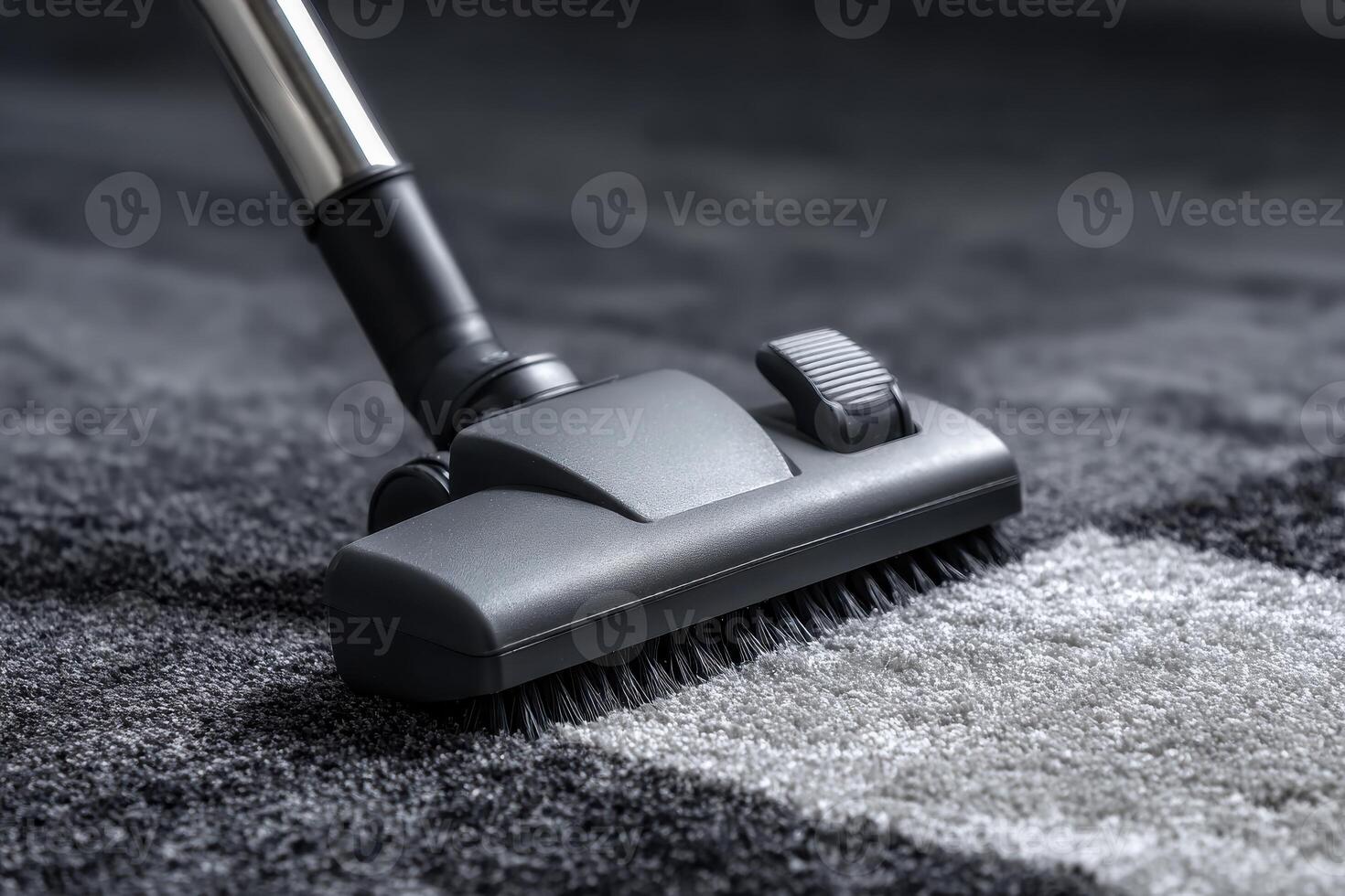 A close up of a vacuum cleaner head on a gray and white carpet showing cleaning in progress photo