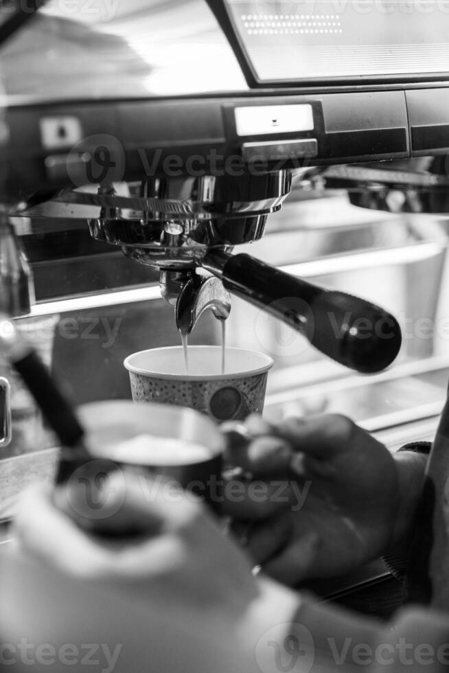 Espresso Being Prepared in a Cafe With a Barista Using a Machine to Extract Coffee in the Morning Light photo