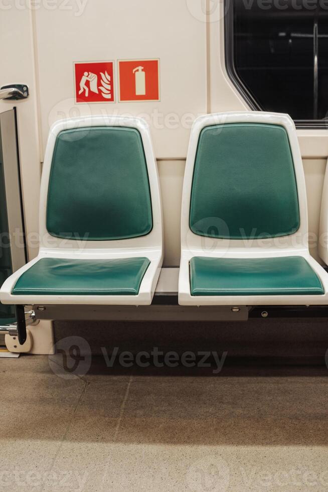 Empty Green and White Seats on a Subway Train in a Urban Transit System at Night photo