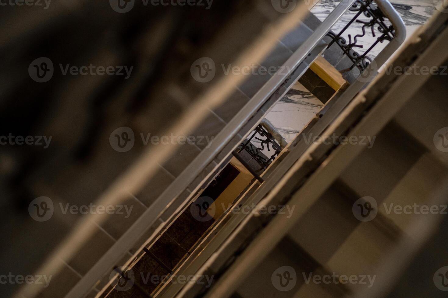 Staircase Interior View With Railings in a Retro Building Showcasing Geometric Lines and Shadows During Daytime photo