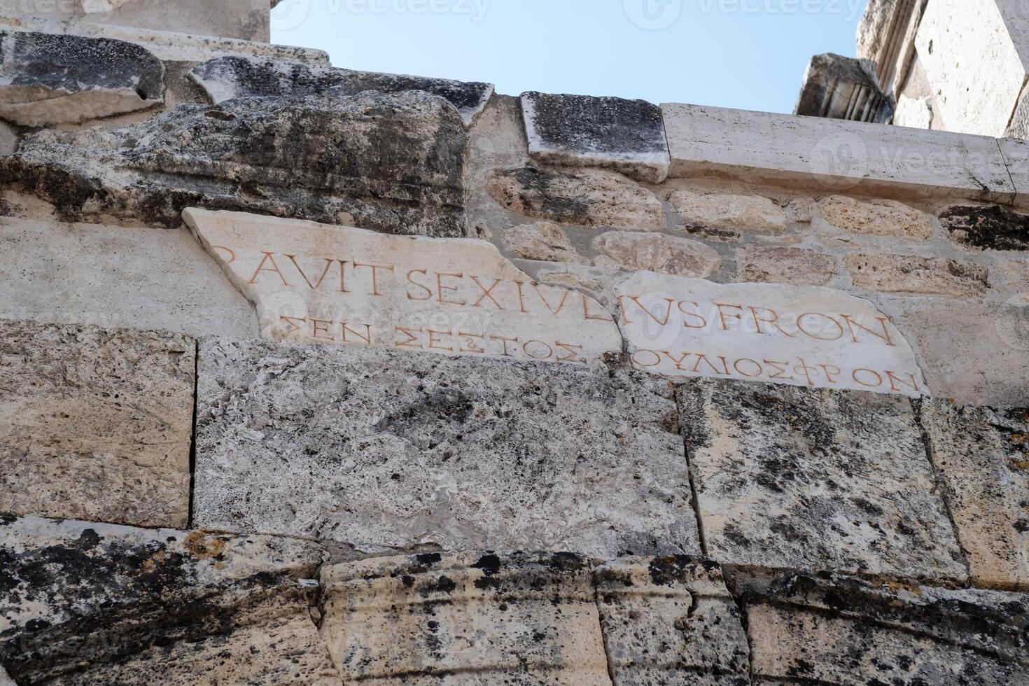 Exploring the Ancient Ruins of Pamukkale With Inscriptions on Stone Walls and Historical Significance in the Sunlight photo