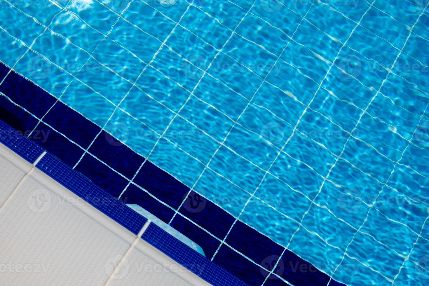 Clear Blue Water in a Swimming Pool With Tiled Edges on a Sunny Day in a Residential Area photo