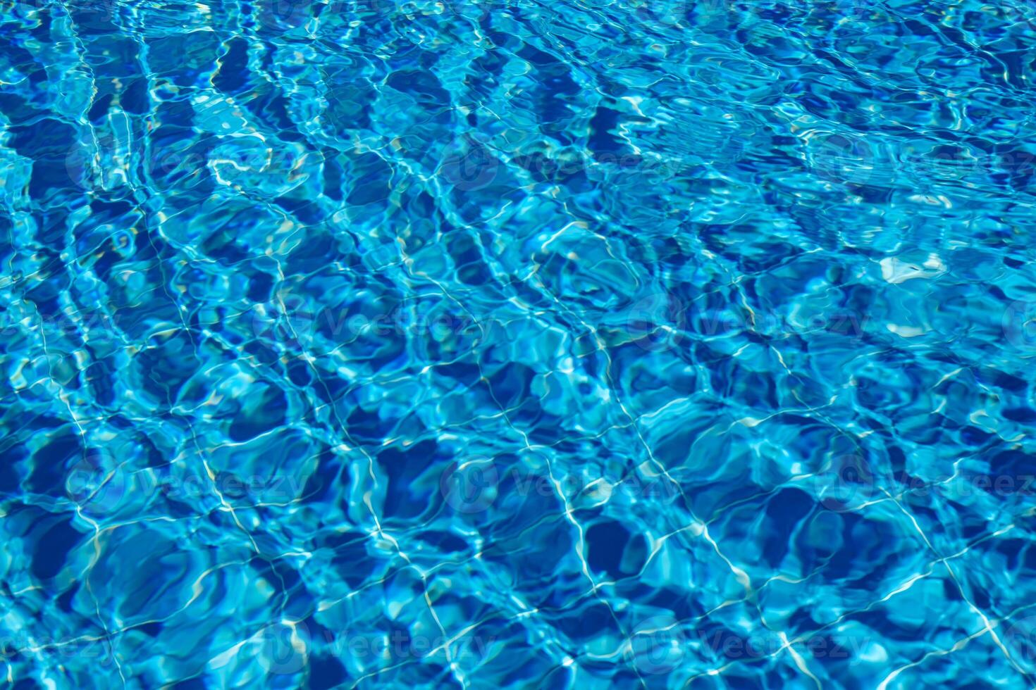 Bright Blue Water Reflecting Sunlight Creates a Serene Atmosphere in a Swimming Pool During a Sunny Afternoon photo