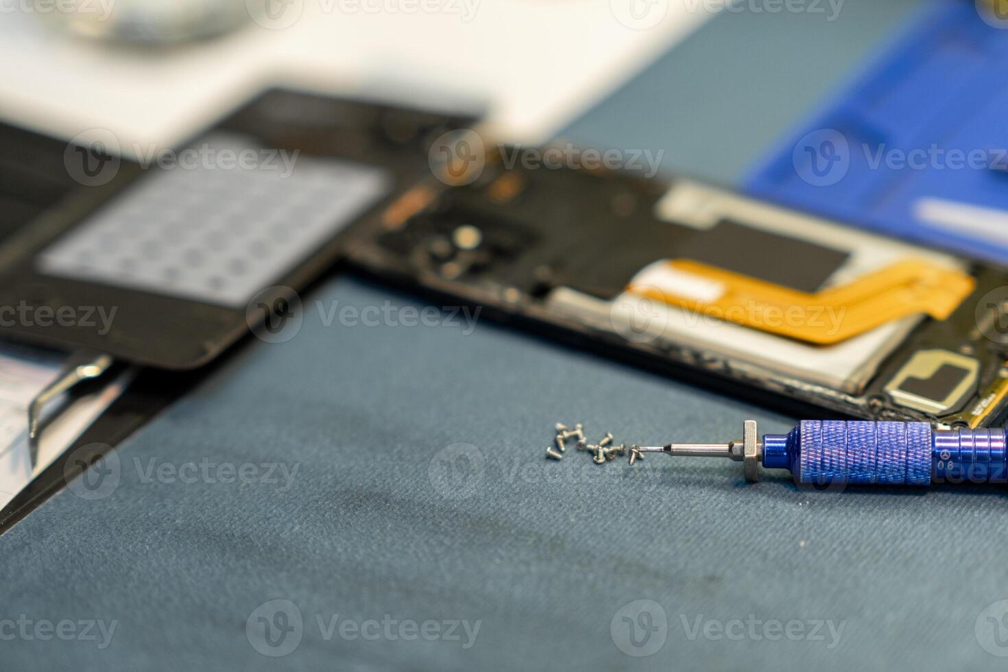 Expert Phone Repair Process Showcasing Disassembled Smartphone Components and Precision Tools in a Workshop Setting photo