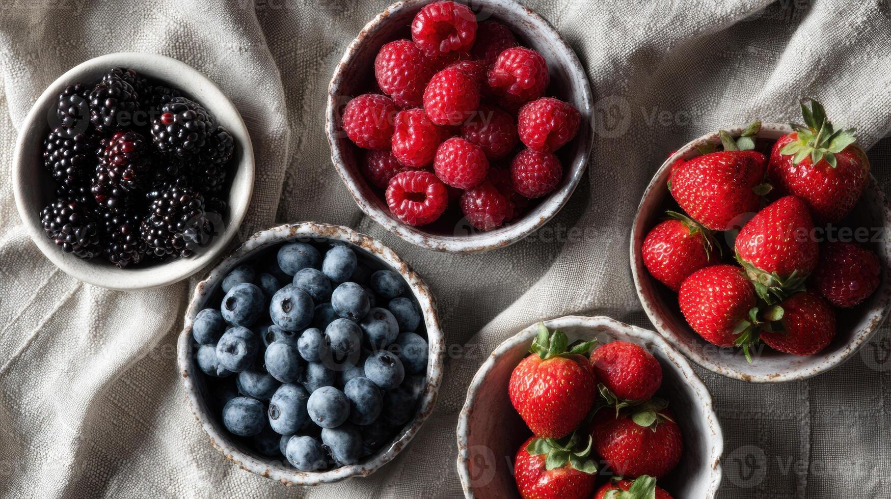 Colorful Display of Fresh Berries in Ceramic Bowls on a Linen Tablecloth in a Cozy Setting During Daylight Hours photo