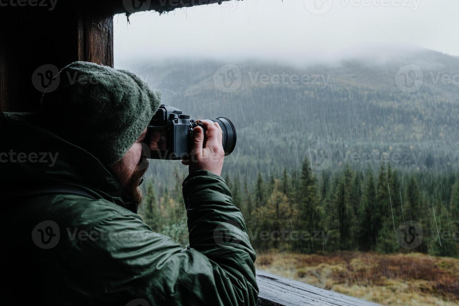A man taking a photo of a forest and mountains