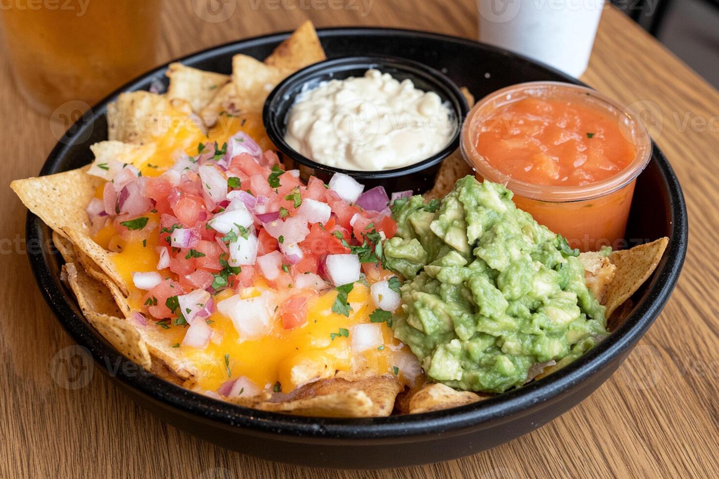 A bowl of nachos with guacamole, salsa and chips photo
