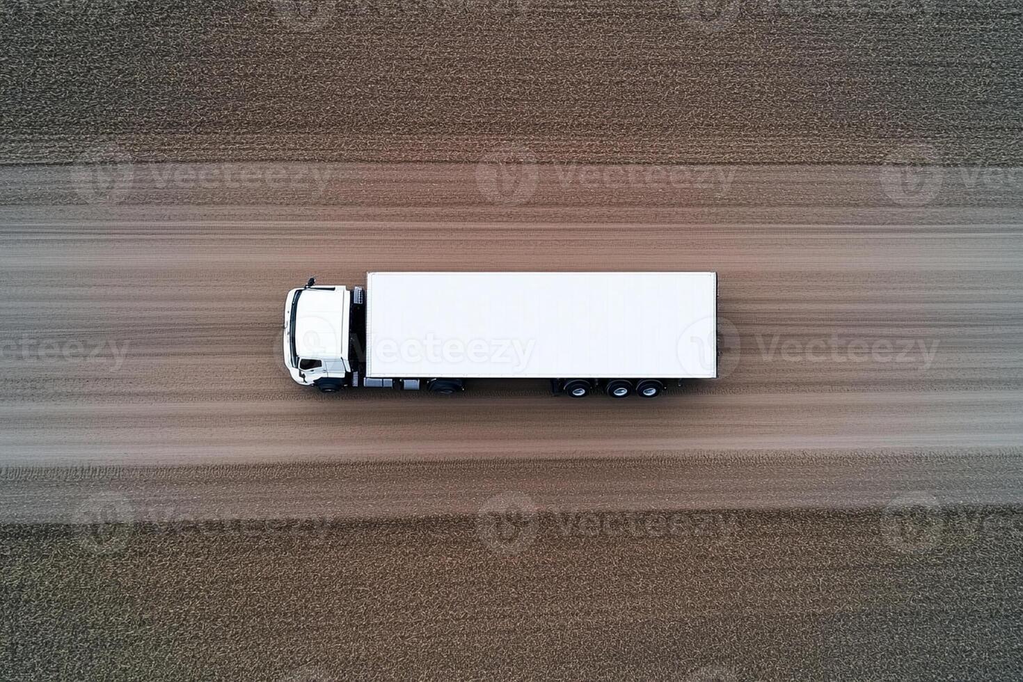 An aerial view of a truck driving on a dirt road photo