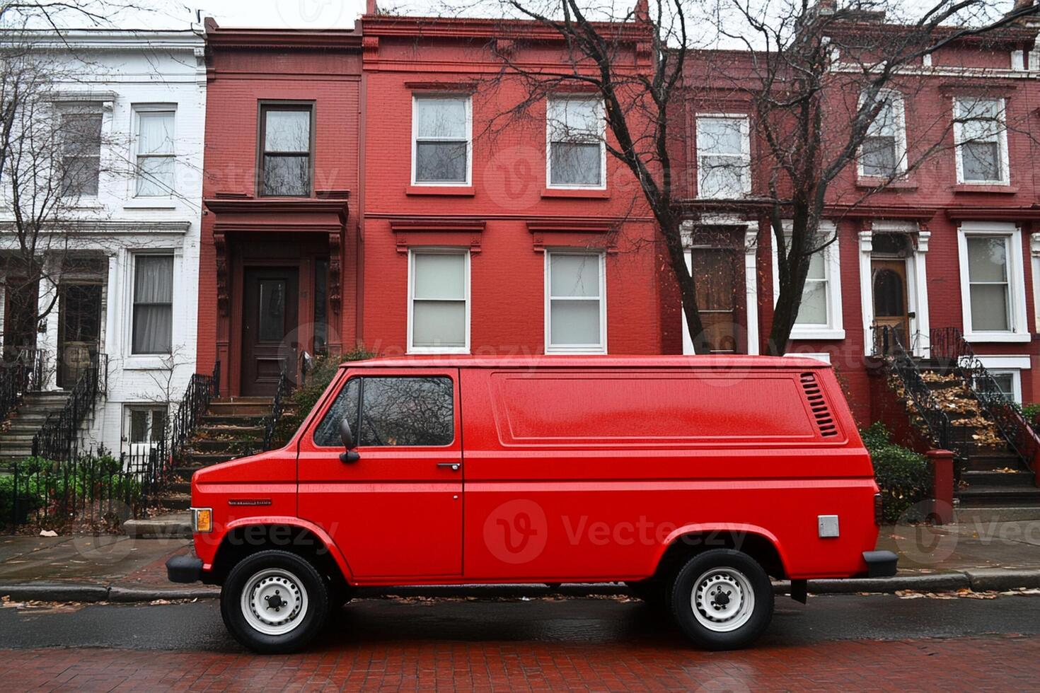 A red van parked in front of a row of red brick houses photo