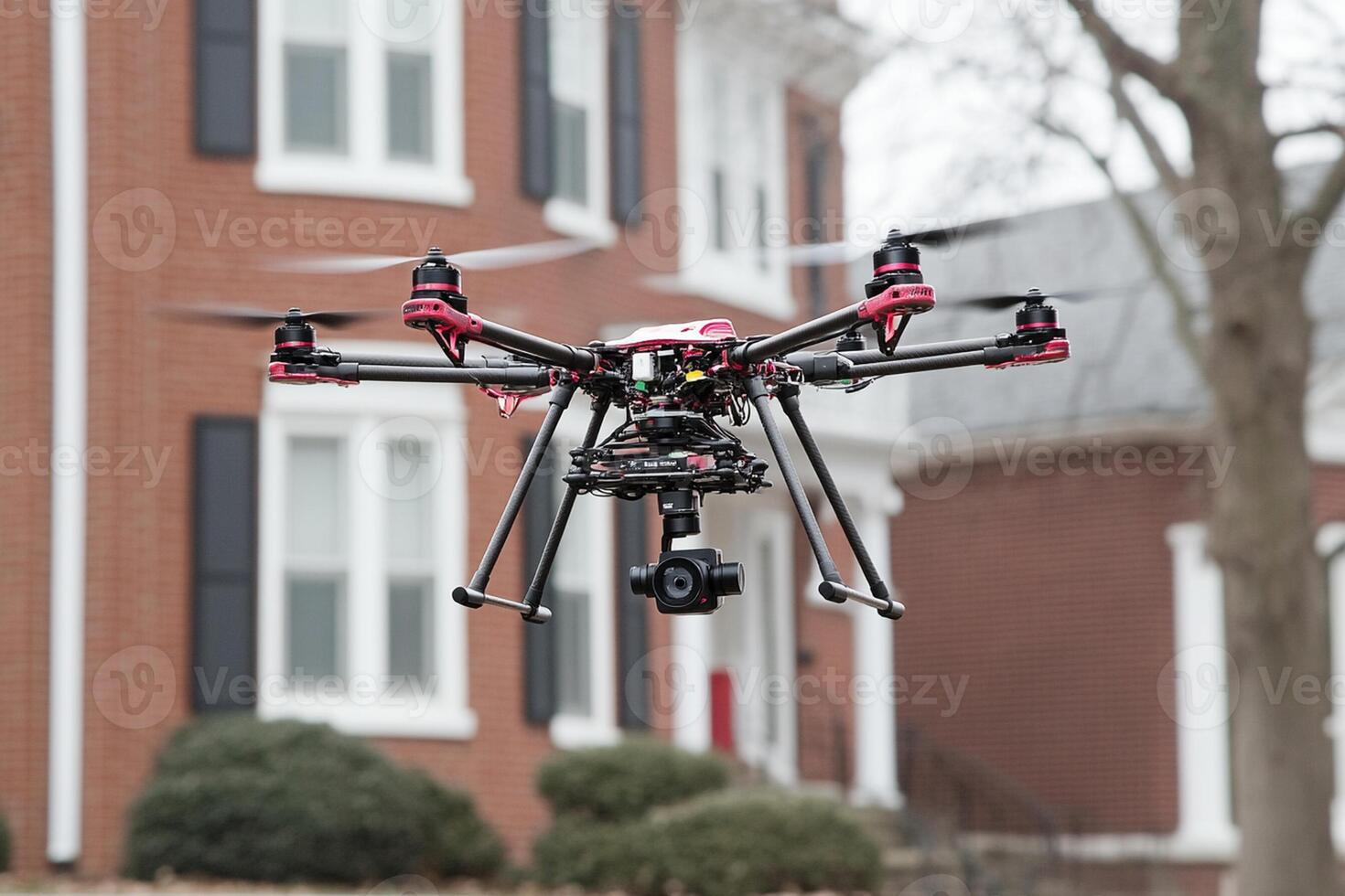 A large black and red drone flying over a house photo