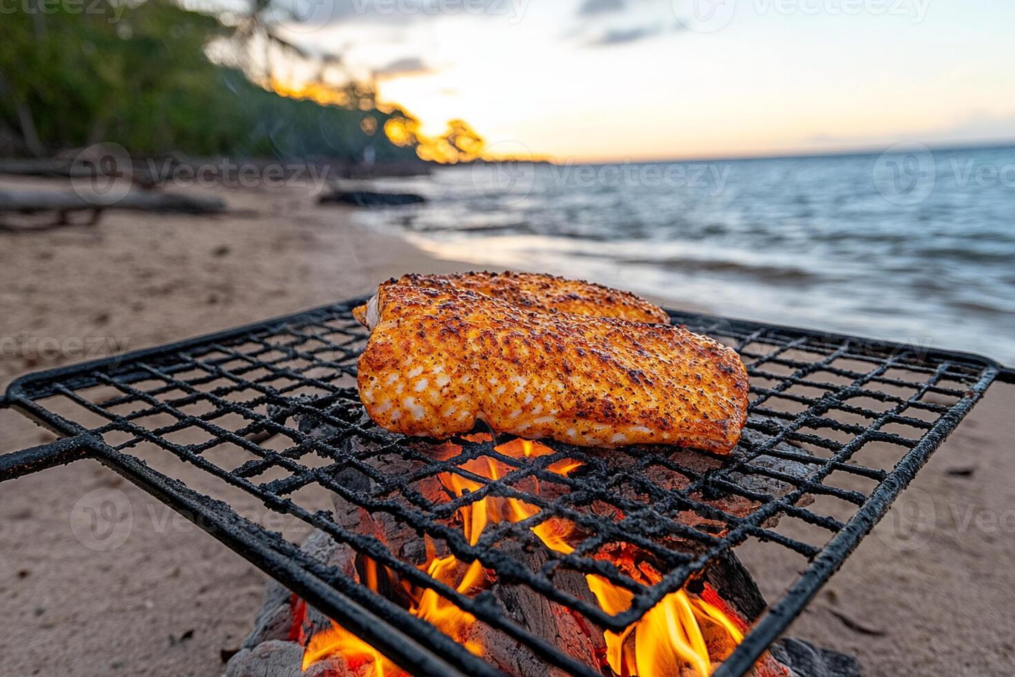 A fish is cooking on a grill on the beach photo