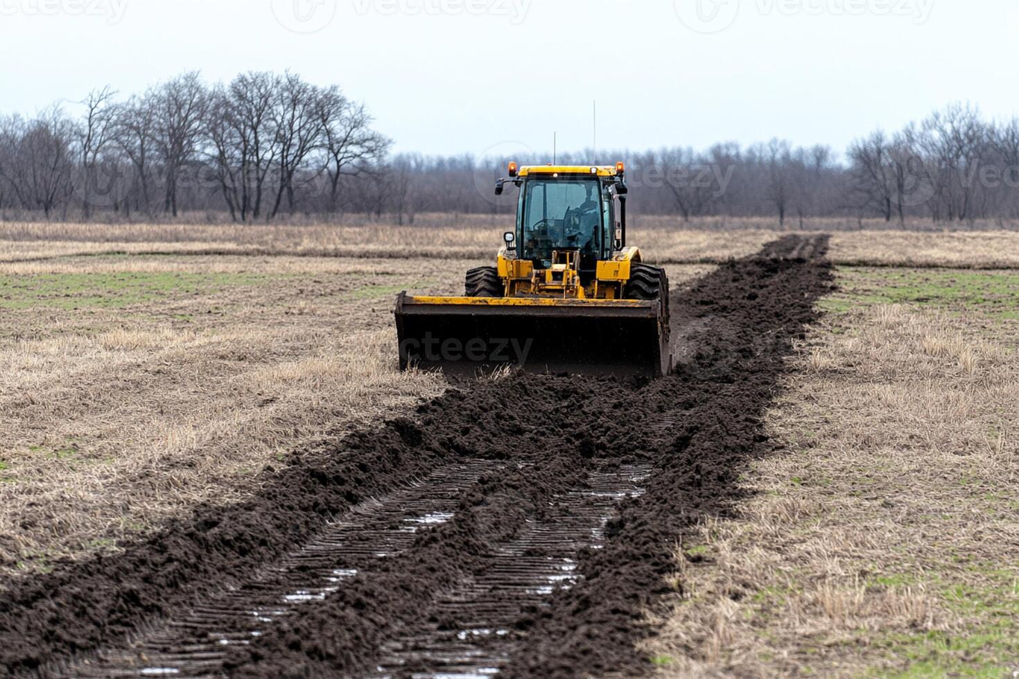 A tractor is plowing a field of dirt photo