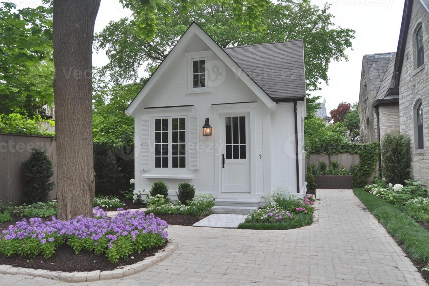 A small white house with a flower garden in front of it photo