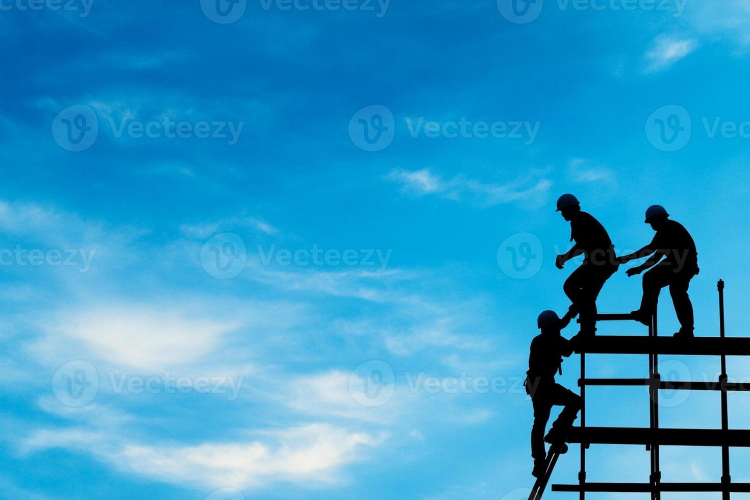 Silhouette of construction workers on scaffolding photo