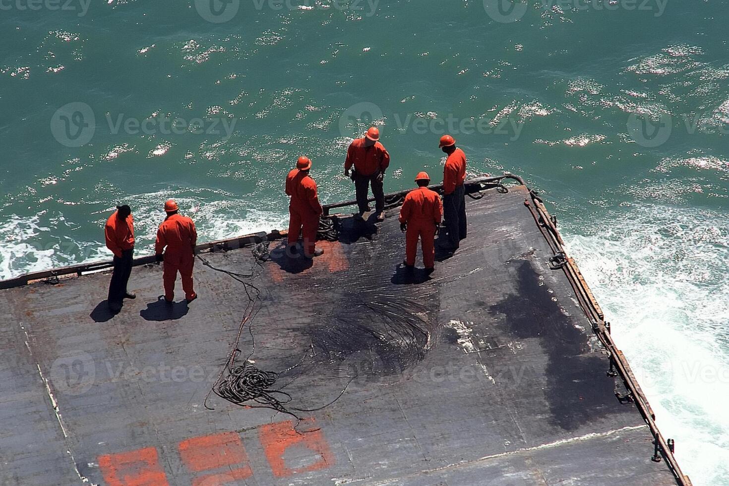 A group of men standing on the deck of a ship photo