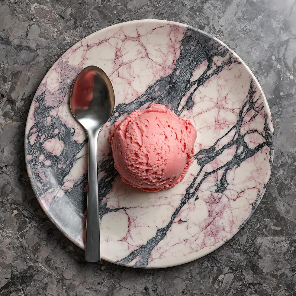 Strawberry Ice Cream Scoop on a Marble Plate with a Spoon. photo