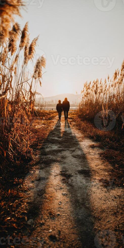 People walking along a path at sunset in late autumn photo