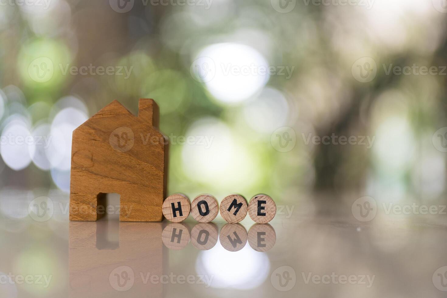 House model with spelling the word home on wood circle block. mortgage for a home. photo