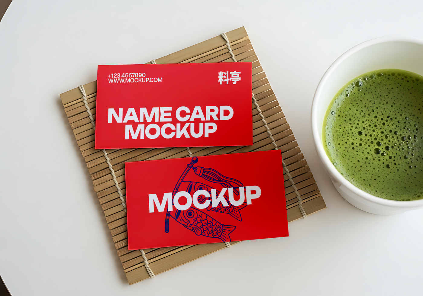 Red name card mockups rest on a bamboo mat beside a cup of matcha psd