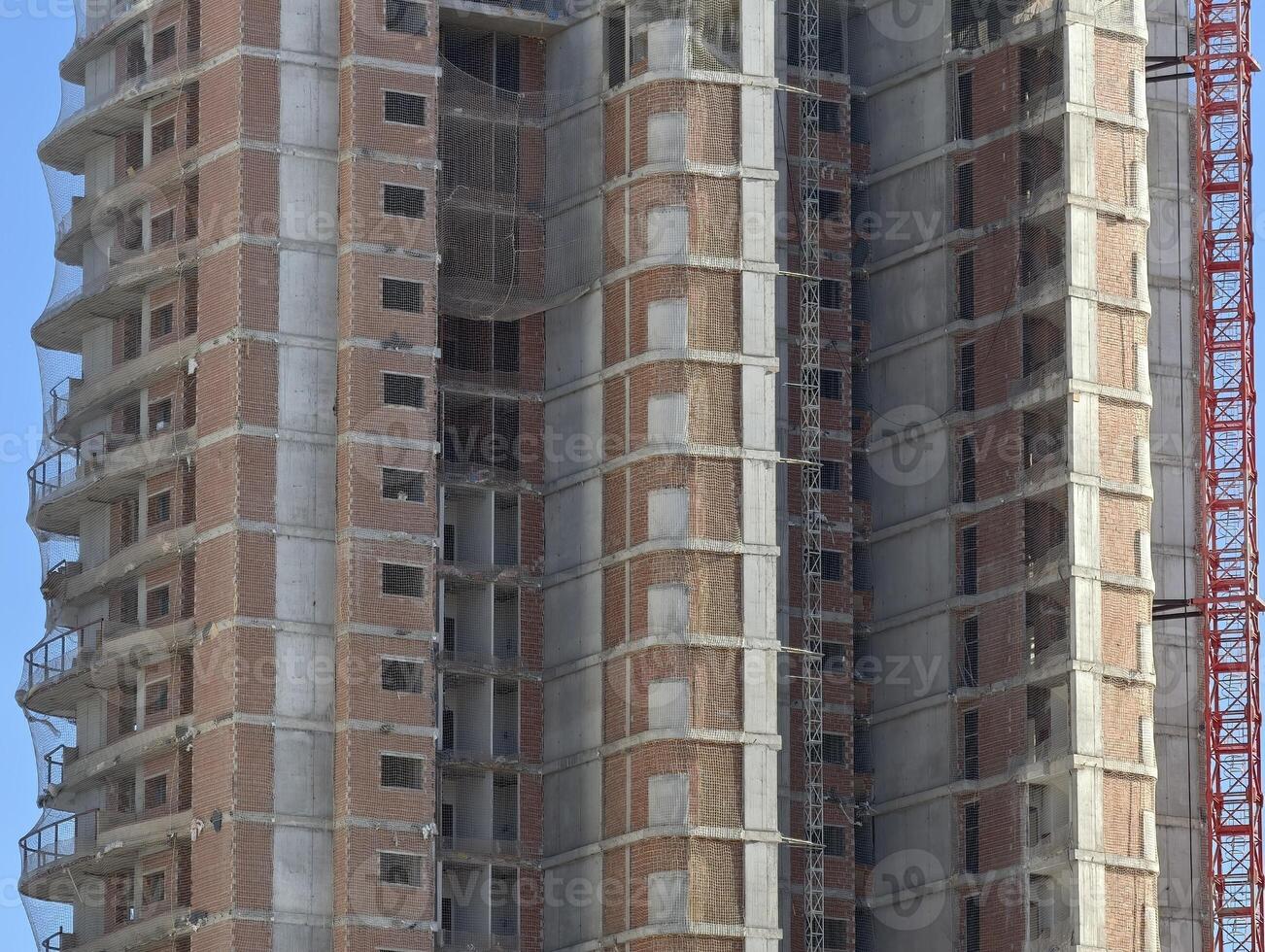 A tall building under construction with crane photo