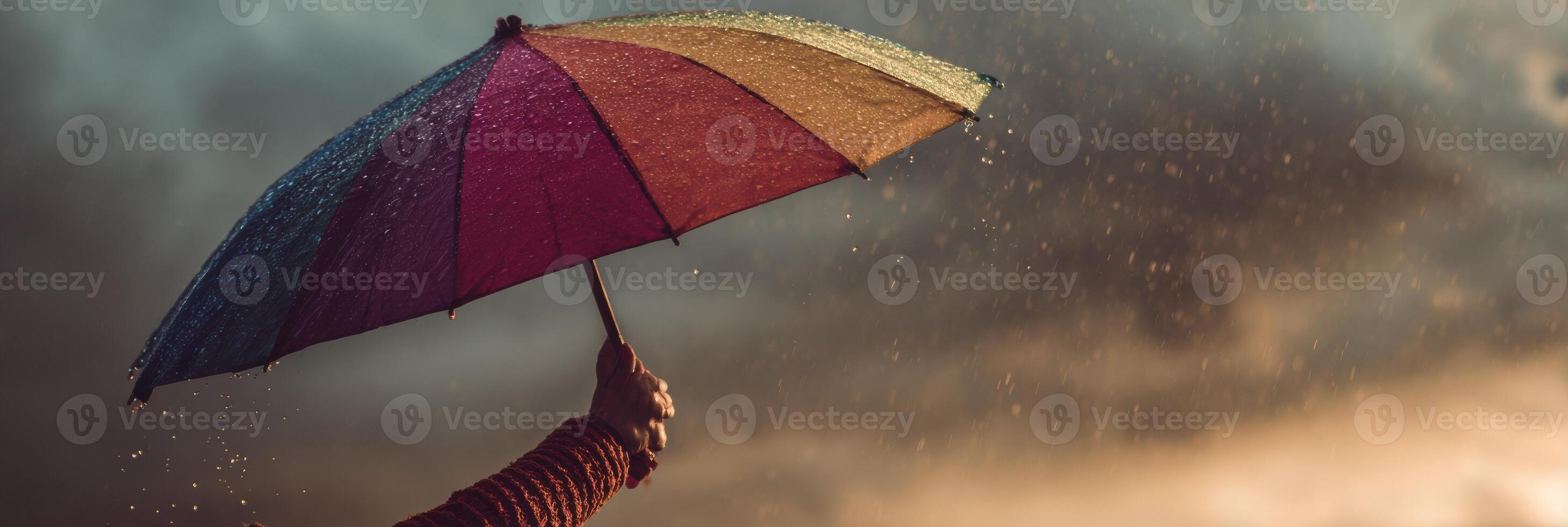 Hand Holds a Rainbow Umbrella During a Storm, Symbolizing Support and Resilience Under Challenging Weather Conditions photo