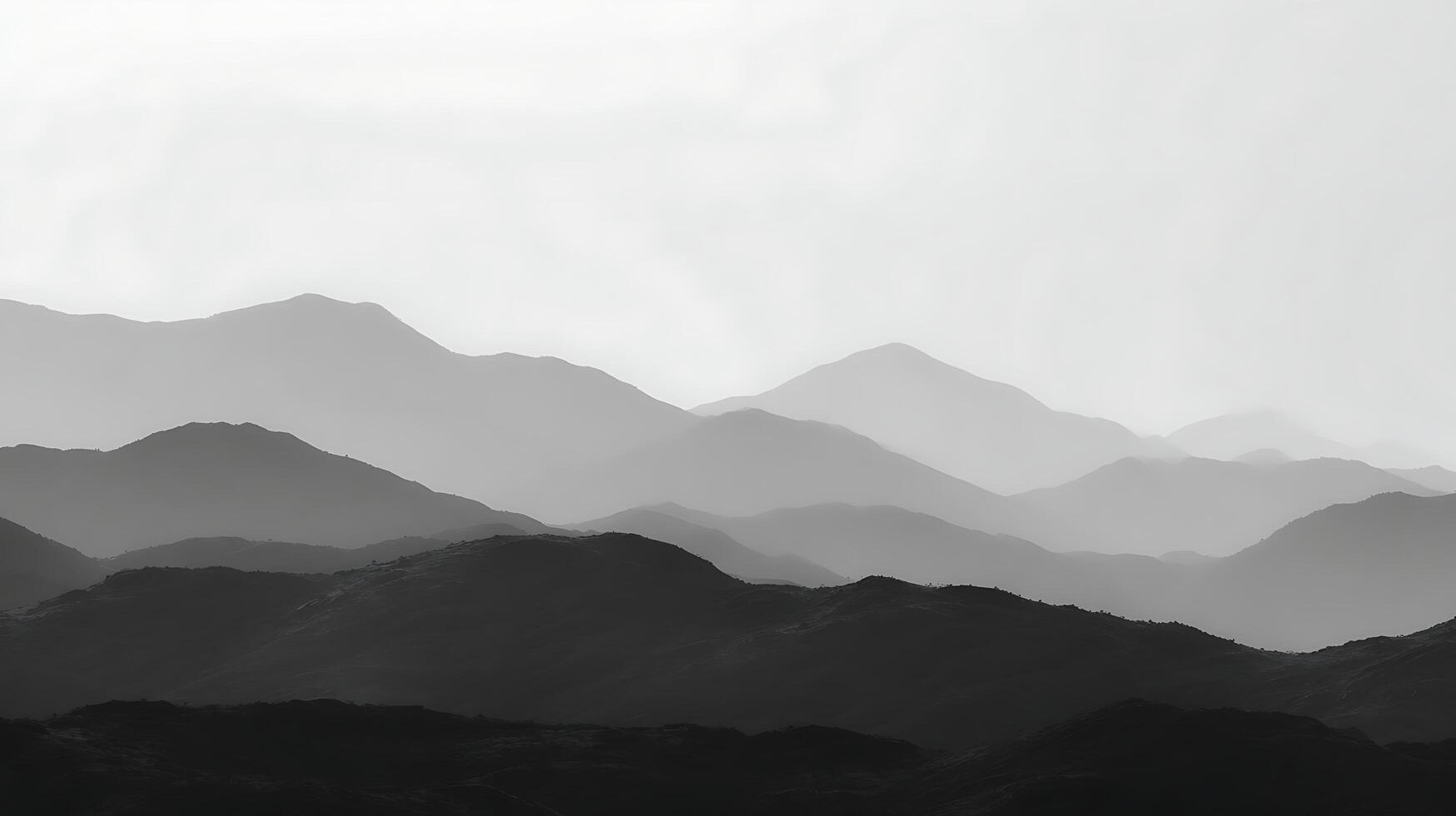 Majestic mountain range silhouettes under a hazy sky. photo