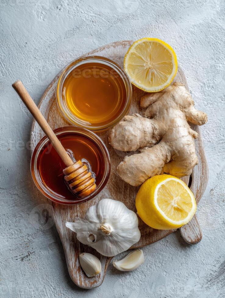 Home Cold Remedies Arranged in a Flat Lay With Honey, Ginger, Garlic, and Lemon on a Wooden Cutting Board photo