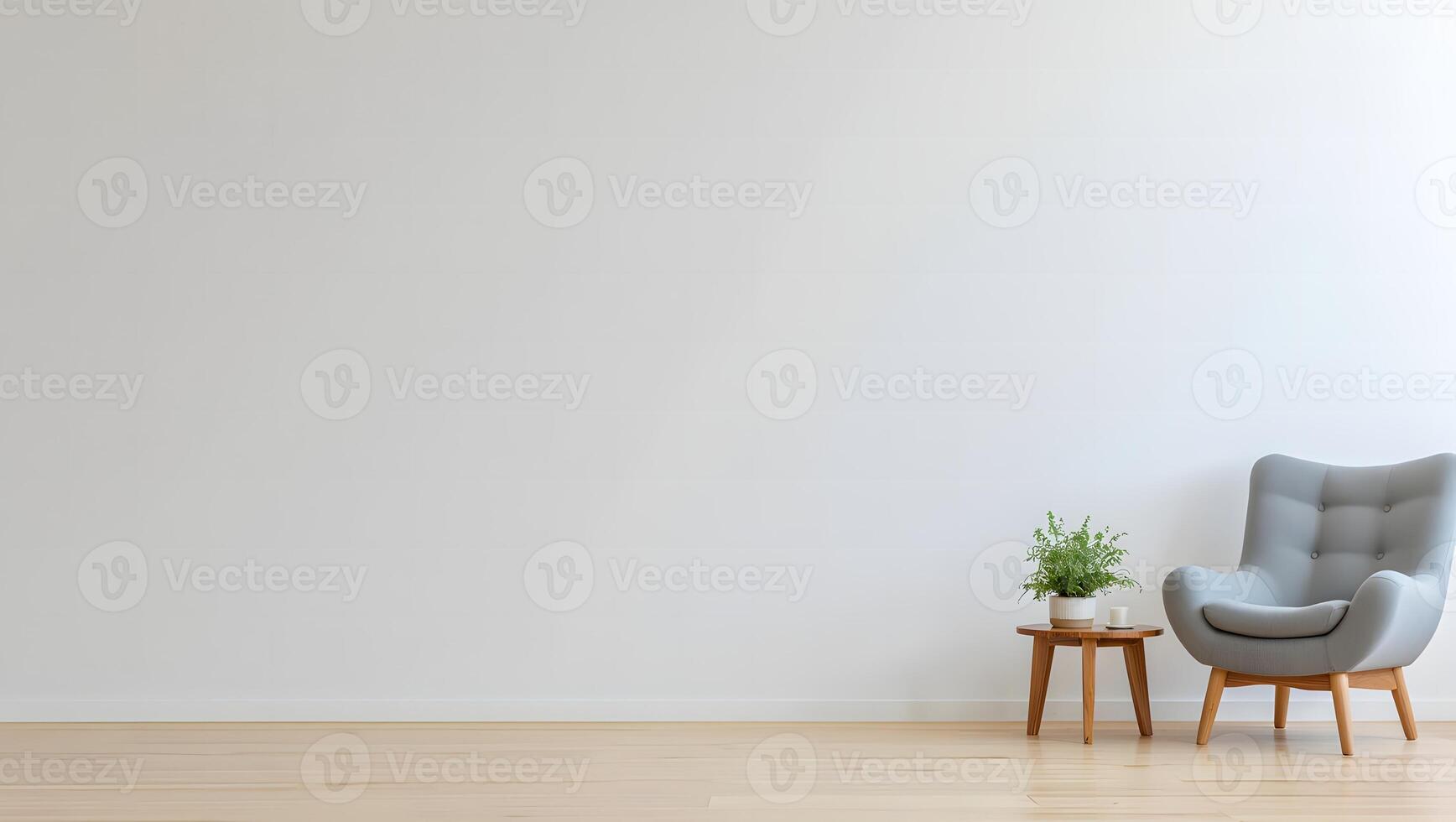 Minimalist interior scene with a comfortable grey armchair and a small wooden side table with a potted plant photo
