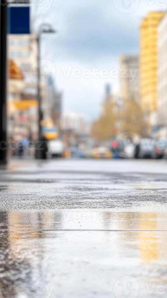 Urban street's wet pavement glistening with city reflections after rain. Blurred background of buildings and traffic creates a serene, atmospheric metropolitan scene. photo