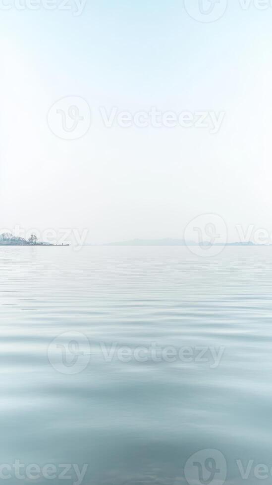 Expansive Serenity A Minimalist Vista of Calm Blue Waters and a Distant Horizon Under a Soft, Clear Sky, Evoking Tranquil Reflection. photo