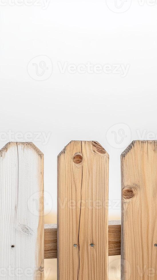 Close-up of a weathered wooden picket fence with natural grain and a clean white background, offering rustic charm and ample copy space. photo