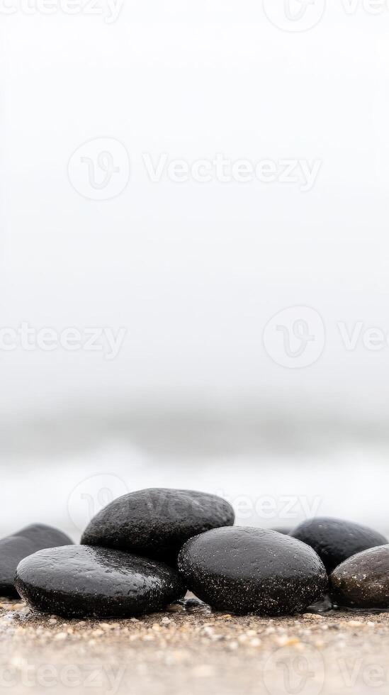 Smooth, Dark Wet Stones on a Tranquil Beach Shore. Serene Coastal Landscape with Natural Pebbles, Evoking Calm and Peaceful Harmony photo