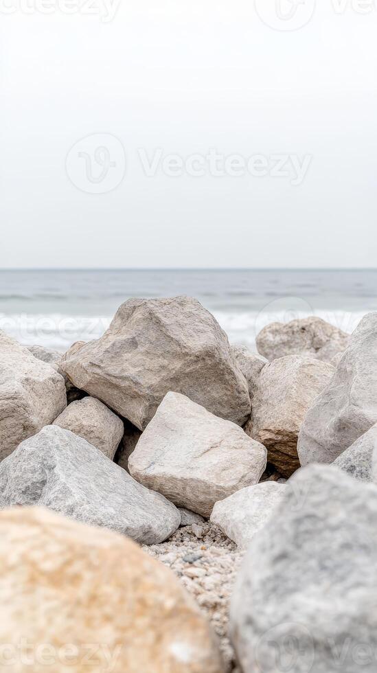 Serene Coastal Landscape with Rugged Grey Rocks and Gentle Ocean Waves Under a Soft Sky, Evoking Natural Tranquility and Earthy Beauty. photo
