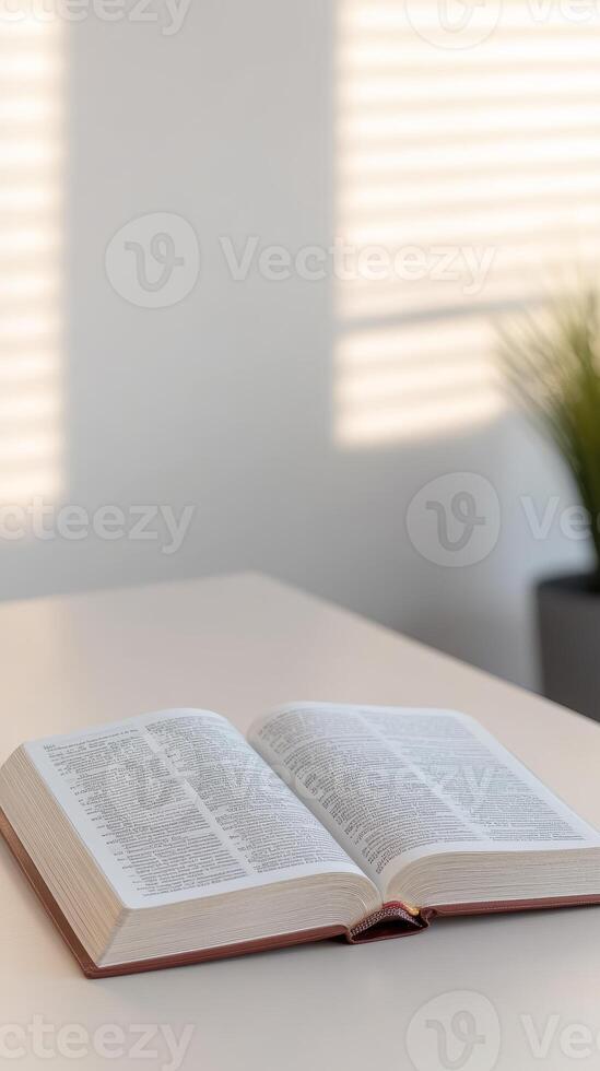 Open Bible on a serene table, illuminated by gentle window light and shadows. Ideal for quiet spiritual study, faith, and peaceful reflection. photo