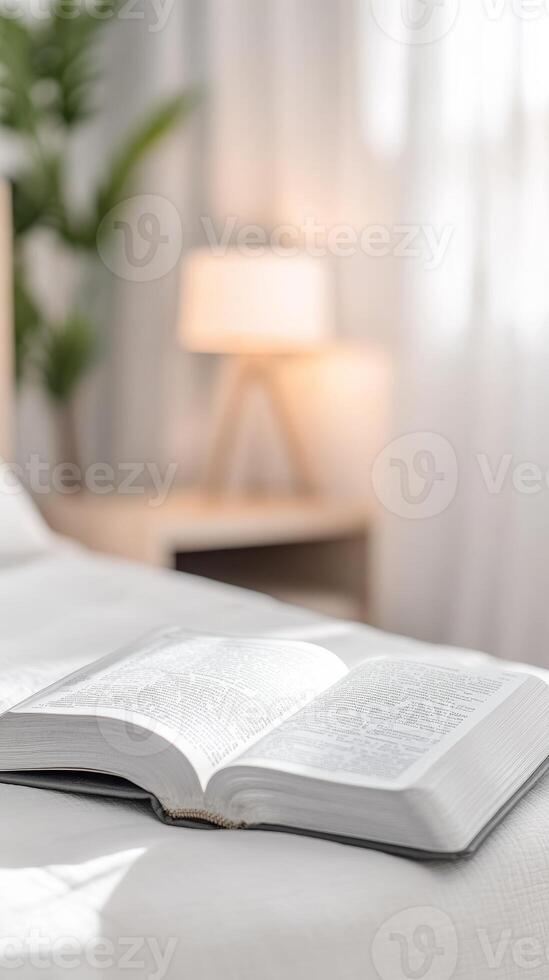 Open Holy Bible resting on a pristine white bed, bathed in soft morning light. A serene scene for spiritual study, quiet reflection, and peaceful devotion. photo