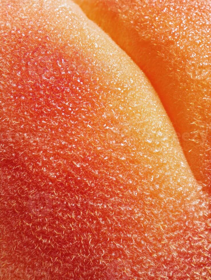 Close-up View of Peach Skin Showcasing Natural Texture and Vibrant Colors in an Abstract Background Setting photo
