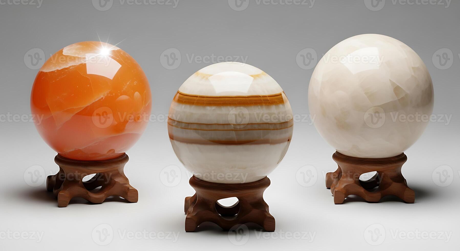 Three polished stone spheres on wooden stands against a plain background photo