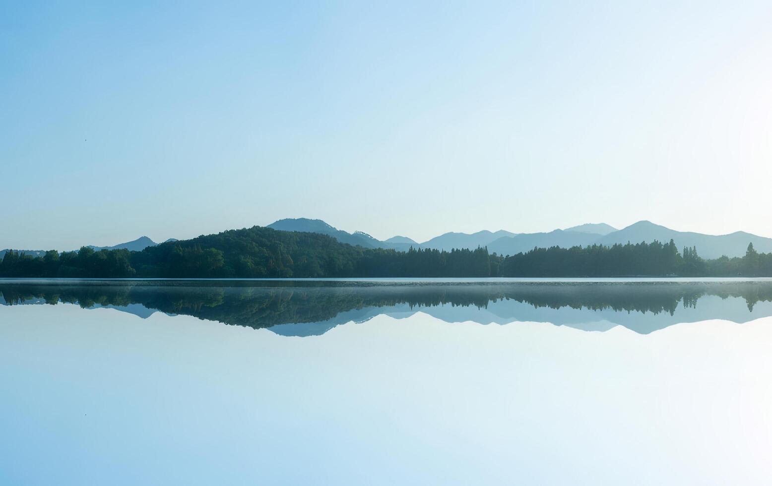 Serene Lake Reflection with Misty Mountains photo