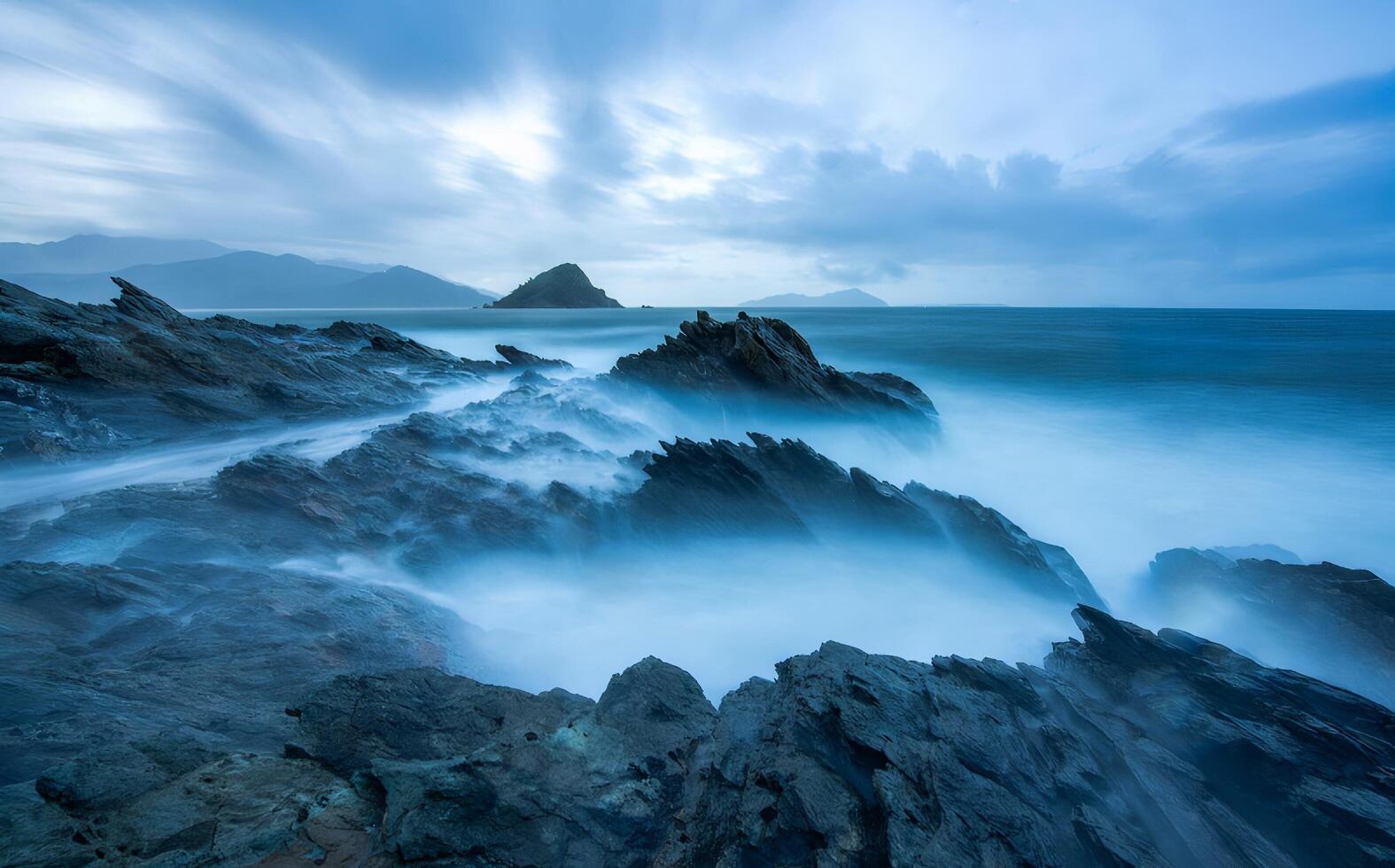 Moody Ocean Landscape with Misty Waves Crashing on Dark Rocks photo