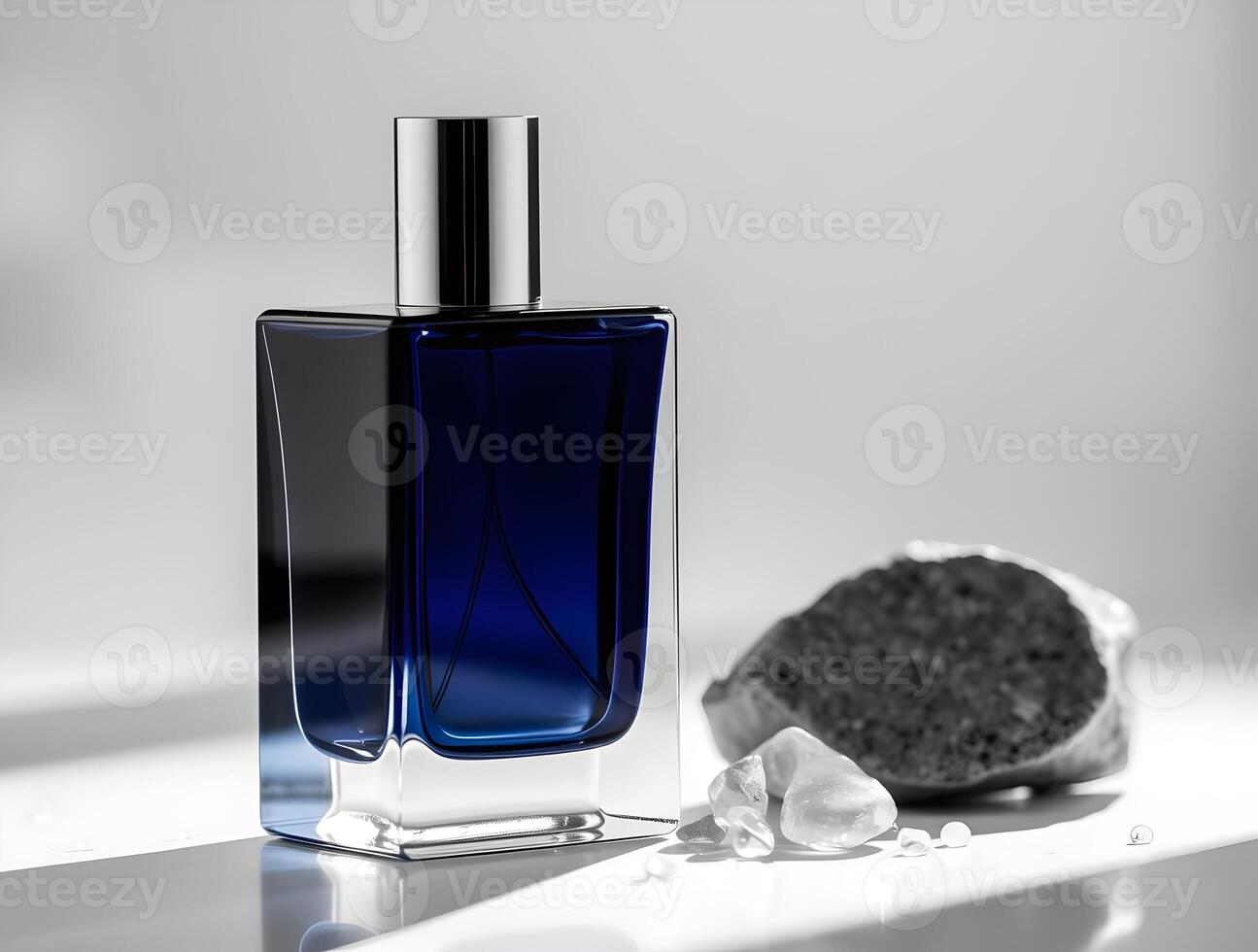 A bottle of perfume sitting on a table next to a rock photo