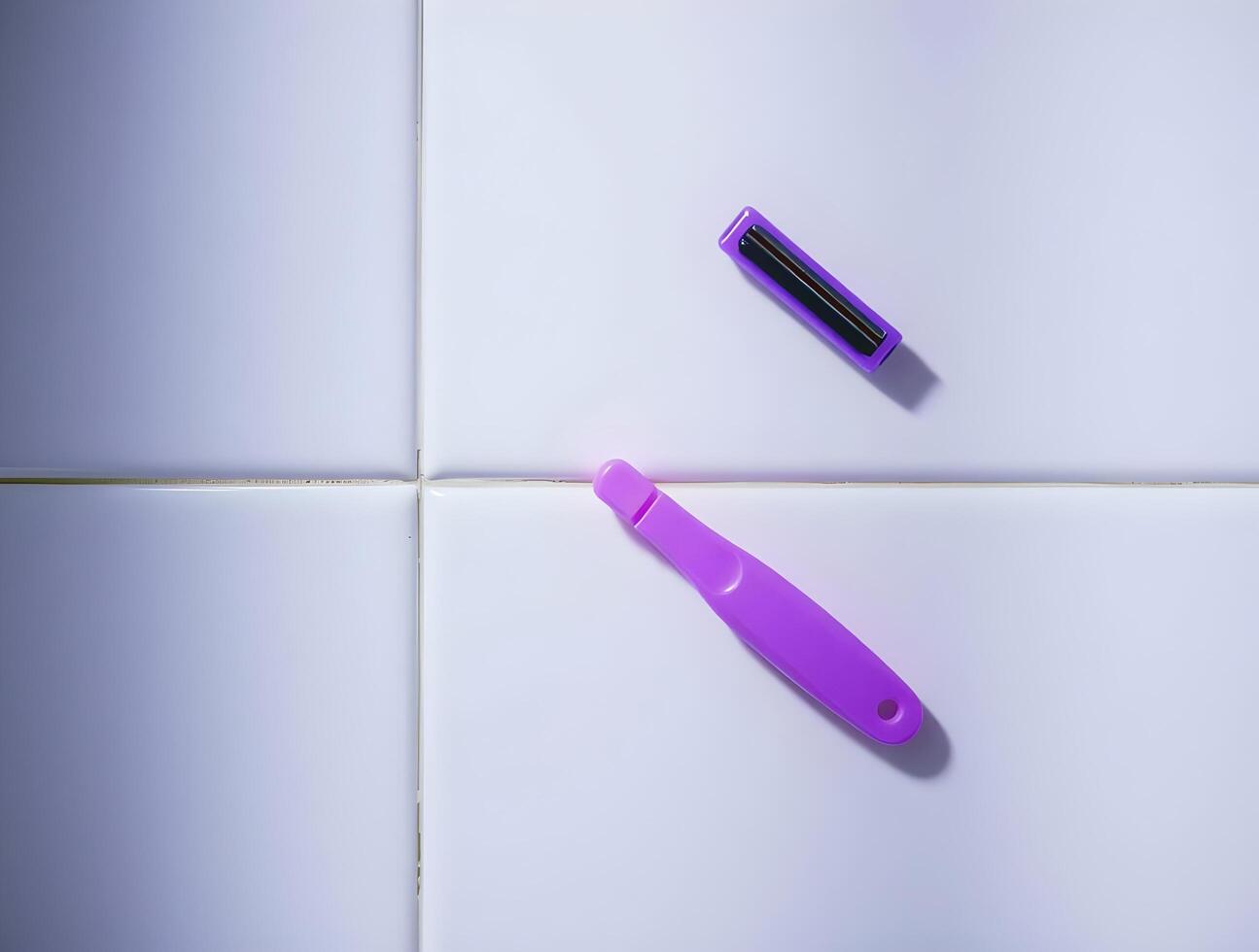 A purple toothbrush and a purple razor on a white tile photo