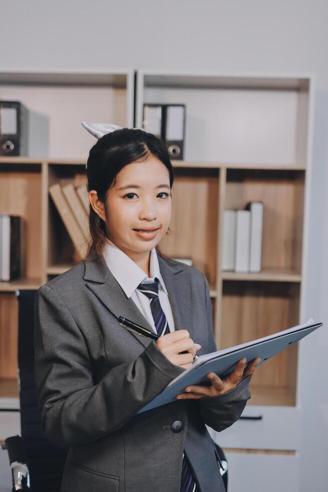 Asian female student in business suit holding a clipboard photo