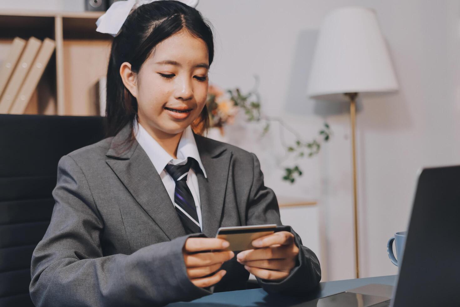 A young girl in a business suit using her phone photo