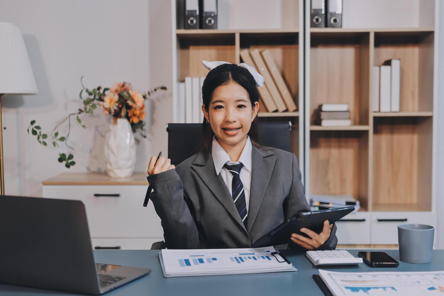 Asian business woman in office with laptop and tablet photo