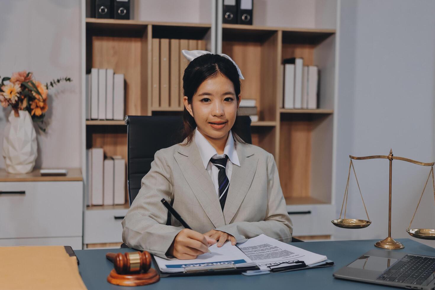 Asian female lawyer sitting at desk with books and papers photo