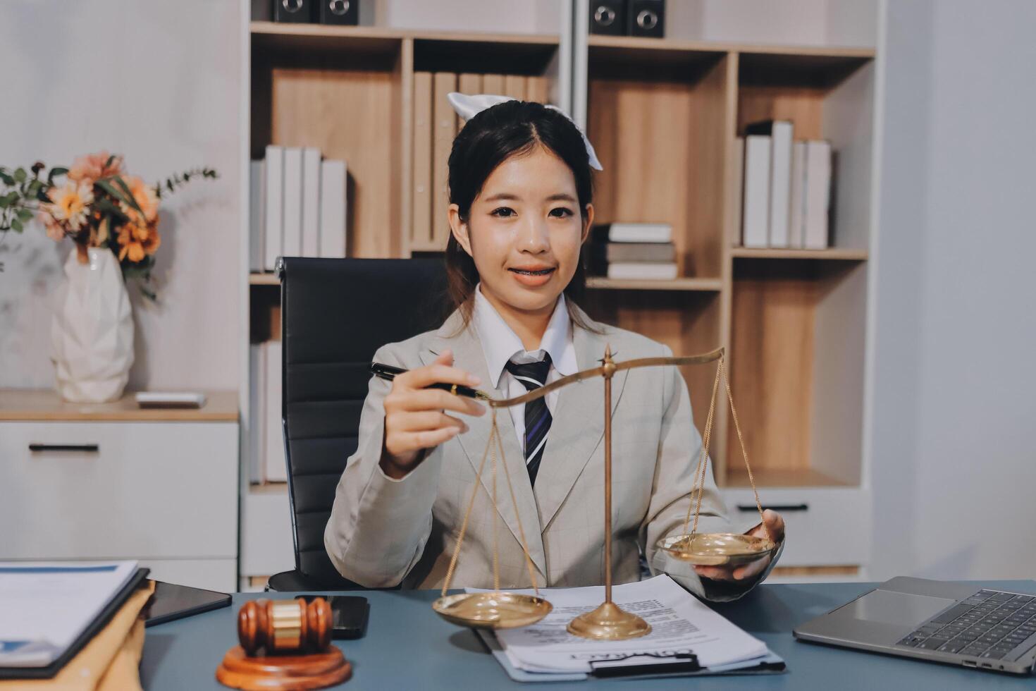 A young woman in a business suit holding a scale of justice photo