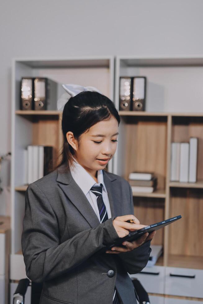Asian nurse in wheelchair using tablet computer in office photo