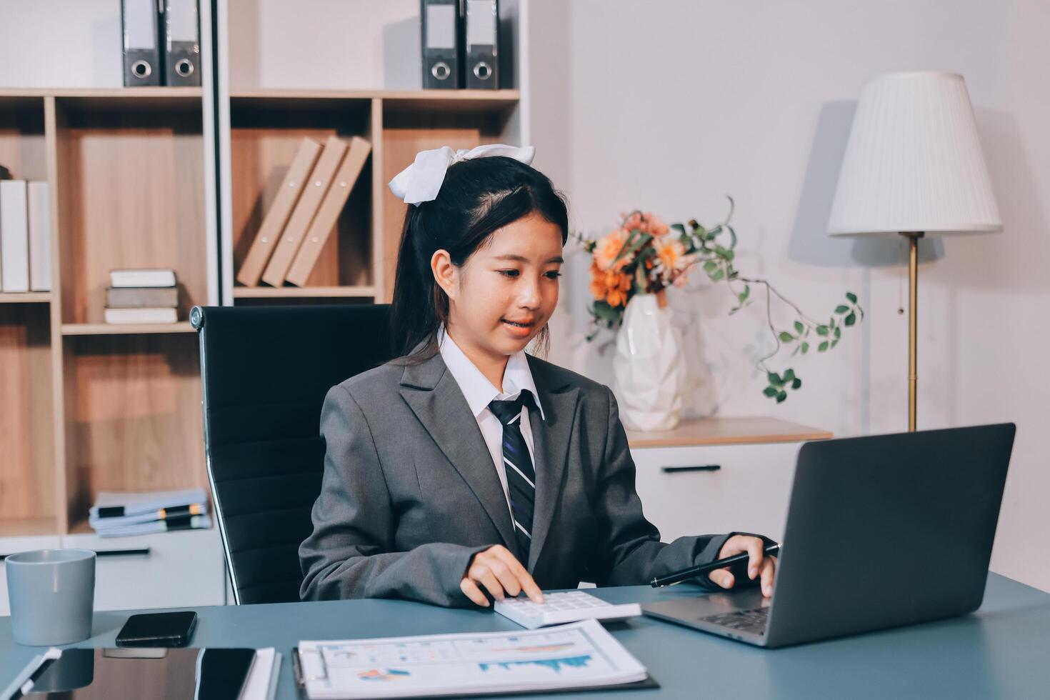 Asian woman in business suit working on laptop photo