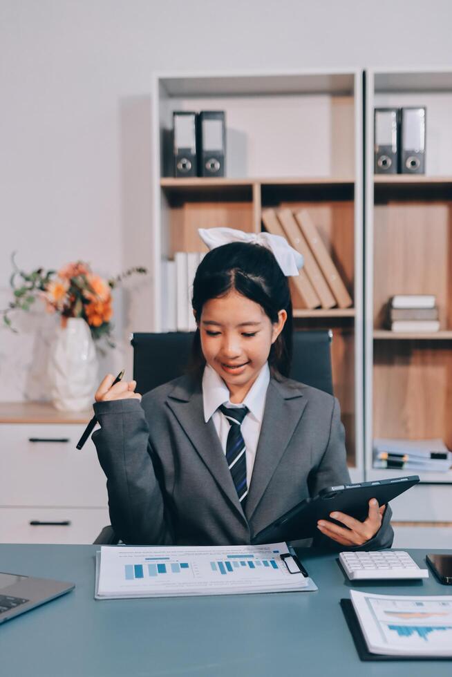 Asian female businesswoman in office with laptop and papers photo